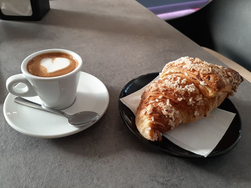 Foto di esempio: cornetto e cappuccino al bar