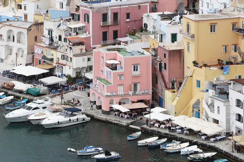 Tavoli e ombrelloni dei ristoranti sul porticciolo della Corricella