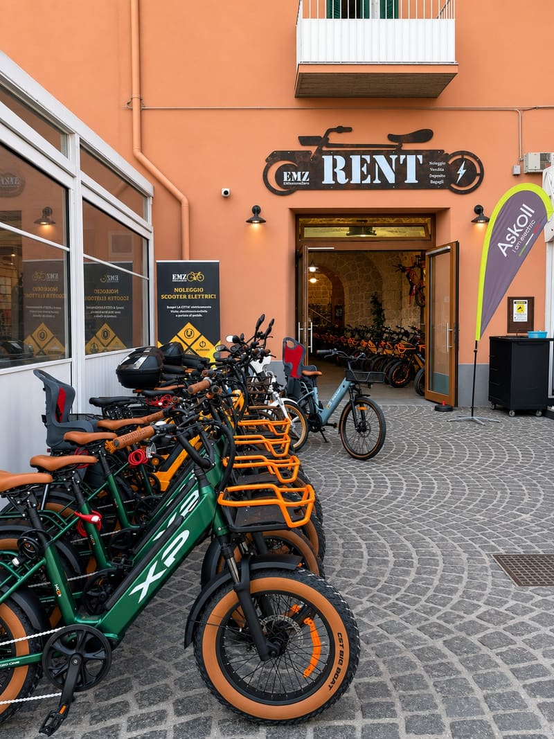 La facciata di RentEMZ in Via Roma 120 a Procida, con l'insegna e le e-bike davanti