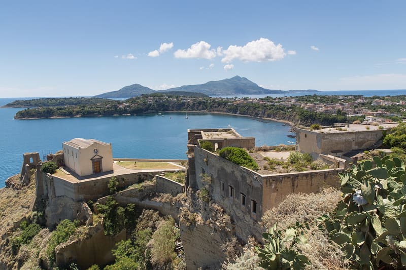 Le mura di Terra Murata sul mare, con Ischia all'orizzonte